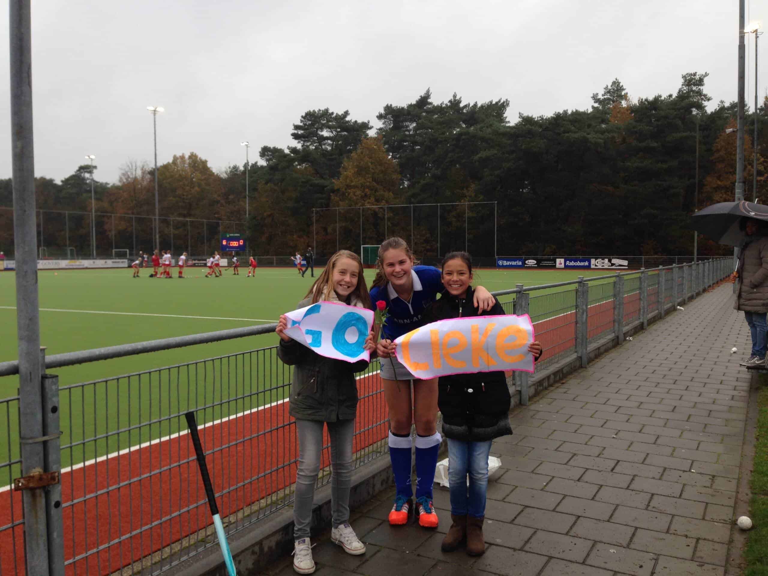 Lieke jaren terug als speelster met twee kinderen die haar aanmoedigen naast het hockeyveld met een spandoek hebben gemaakt met 'go Lieke'